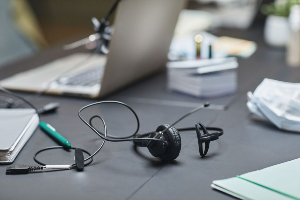 Laptop med headset og notesblok klar til et online møde